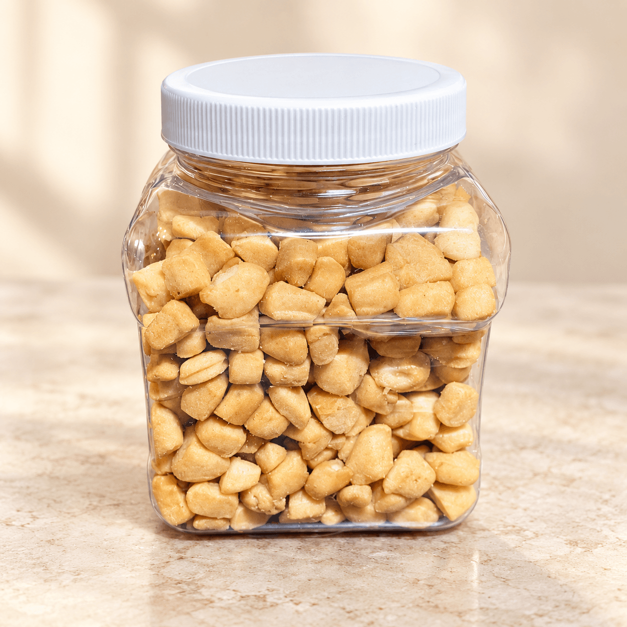 A white-lidded jar filled with sweet golden Chin Chin.